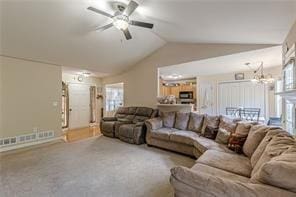 living room featuring lofted ceiling, ceiling fan with notable chandelier, and carpet flooring