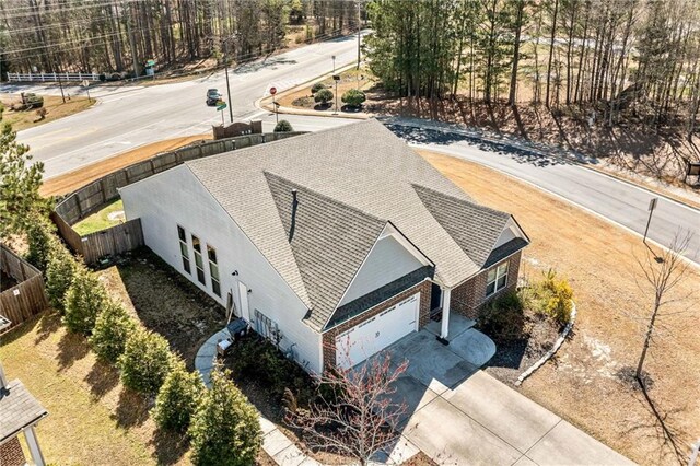 view of front of property with a tennis court, fence, and brick siding