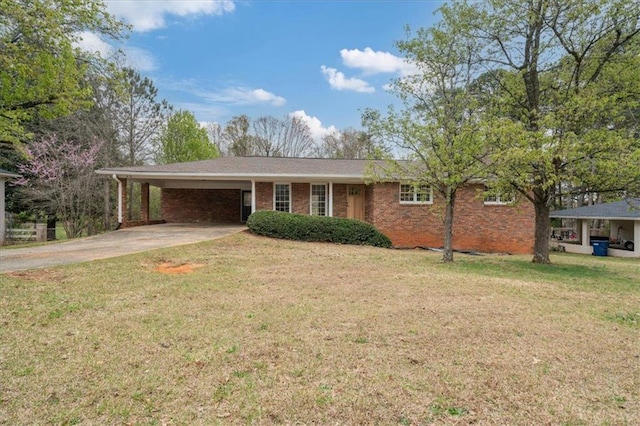 ranch-style house with an attached carport, brick siding, concrete driveway, and a front yard