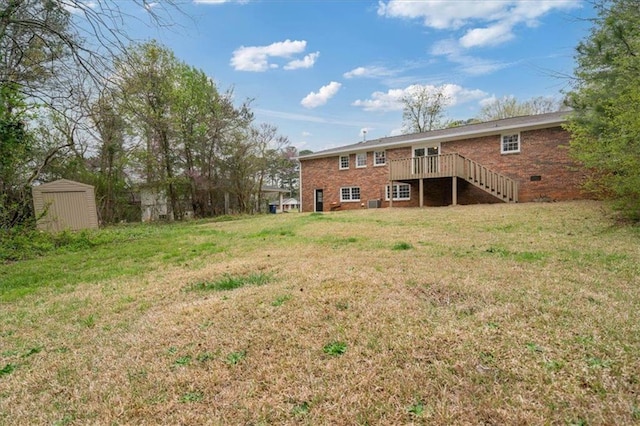 view of yard featuring an outdoor structure, a deck, stairway, and a shed