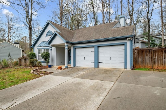 view of front of home featuring fence, a chimney, a shingled roof, concrete driveway, and a garage