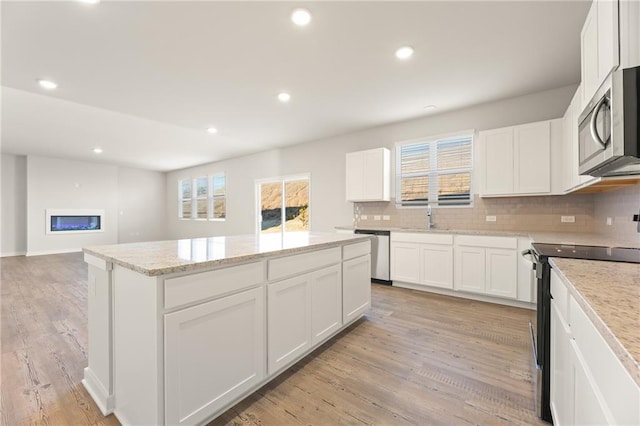 4032 Trimrose Ct, Atlanta, GA 30349 - kitchen featuring stainless steel appliances, a sink, a kitchen island, backsplash, and plenty of natural light