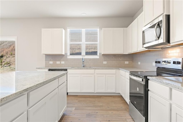 4032 Trimrose Ct, Atlanta, GA 30349 - kitchen featuring appliances with stainless steel finishes, a sink, white cabinets, and tasteful backsplash