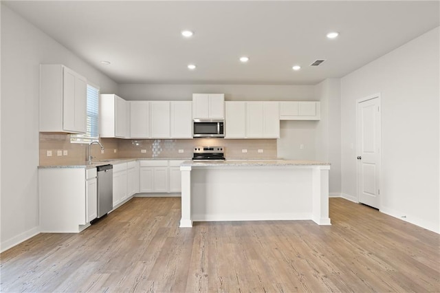 4032 Trimrose Ct, Atlanta, GA 30349 - kitchen with stainless steel appliances, backsplash, white cabinets, and recessed lighting