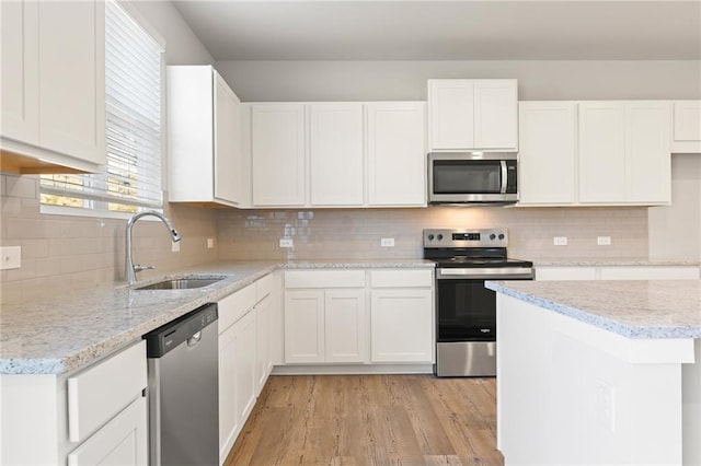 4032 Trimrose Ct, Atlanta, GA 30349 - kitchen with stainless steel appliances, a sink, white cabinetry, and light wood-style flooring