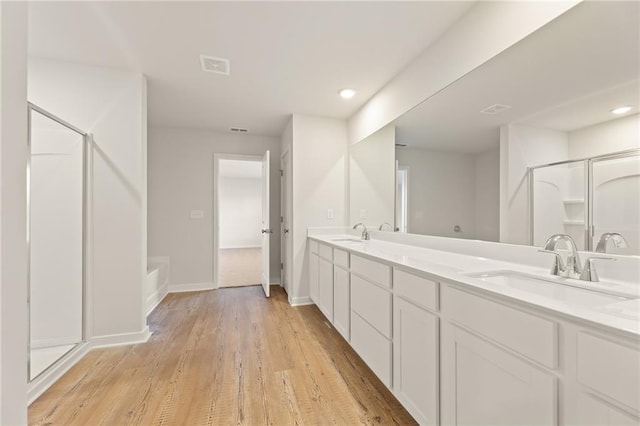 4032 Trimrose Ct, Atlanta, GA 30349 - bathroom with a shower with door, double vanity, wood finished floors, a tub, and recessed lighting