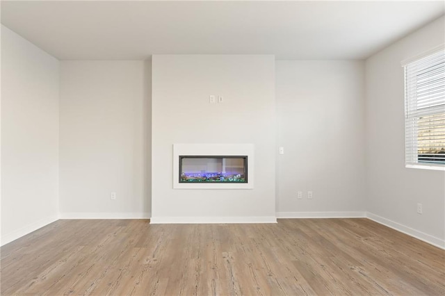 4032 Trimrose Ct, Atlanta, GA 30349 - unfurnished living room featuring wood finished floors, baseboards, and a glass covered fireplace