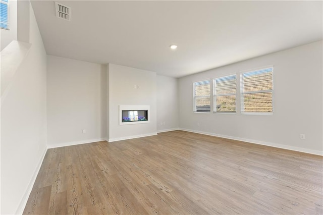 4032 Trimrose Ct, Atlanta, GA 30349 - unfurnished living room with a glass covered fireplace, light wood-style flooring, baseboards, and recessed lighting