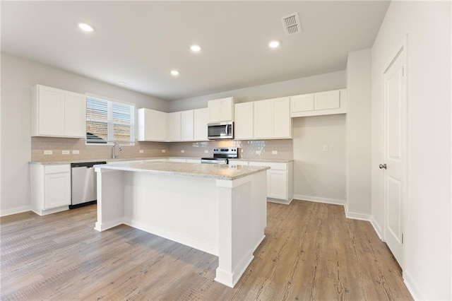 4032 Trimrose Ct, Atlanta, GA 30349 - kitchen with appliances with stainless steel finishes, a center island, white cabinetry, and recessed lighting