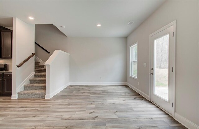 empty room with ceiling fan and light hardwood / wood-style flooring