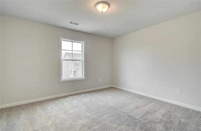 unfurnished bedroom featuring a closet, a walk in closet, light carpet, and a tray ceiling