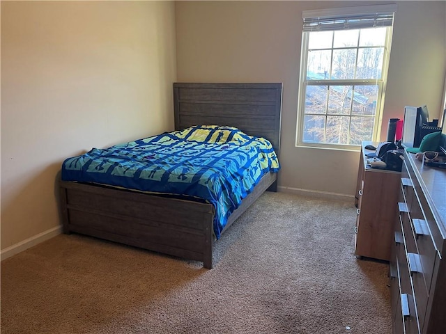 carpeted bedroom featuring multiple windows and baseboards