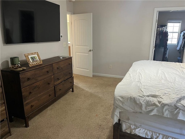 bedroom with light colored carpet and baseboards