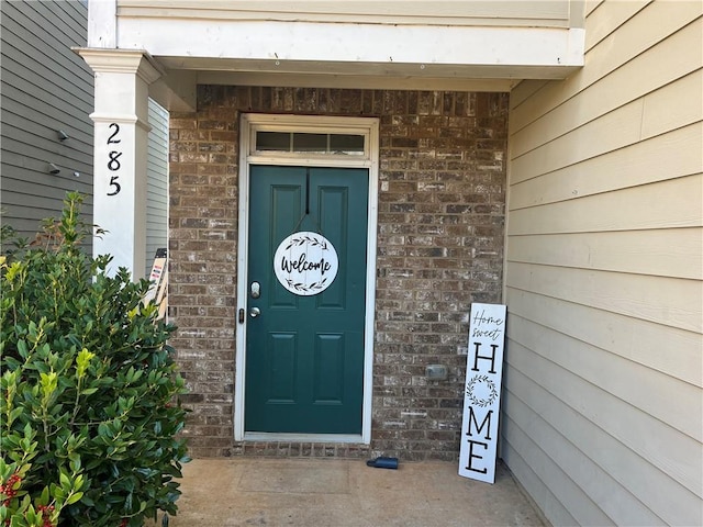 doorway to property with brick siding