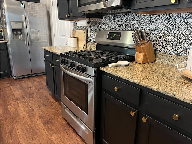 kitchen with dark wood finished floors, backsplash, stainless steel appliances, and dark cabinets