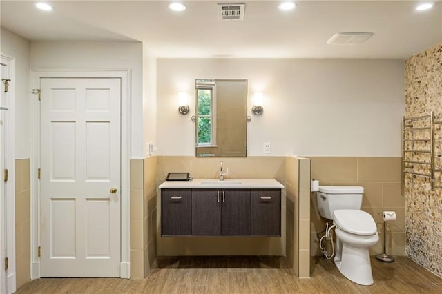 44 Muscogee Ave NW, Atlanta, GA 30305 - bathroom with tile walls, wood finished floors, toilet, a wainscoted wall, and vanity