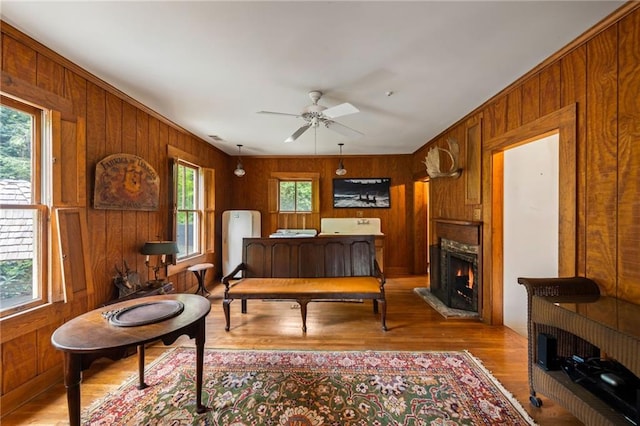 44 Muscogee Ave NW, Atlanta, GA 30305 - living area featuring wooden walls, wood finished floors, a warm lit fireplace, and ceiling fan