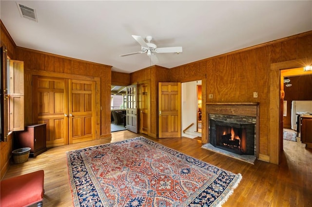 44 Muscogee Ave NW, Atlanta, GA 30305 - living area featuring wooden walls, ceiling fan, wood finished floors, and a warm lit fireplace