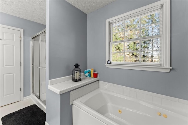 full bath featuring a shower stall, a textured ceiling, and a tub with jets