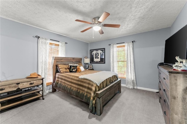 carpeted bedroom with ceiling fan, a textured ceiling, and baseboards