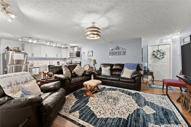 living room with a textured ceiling and wood finished floors