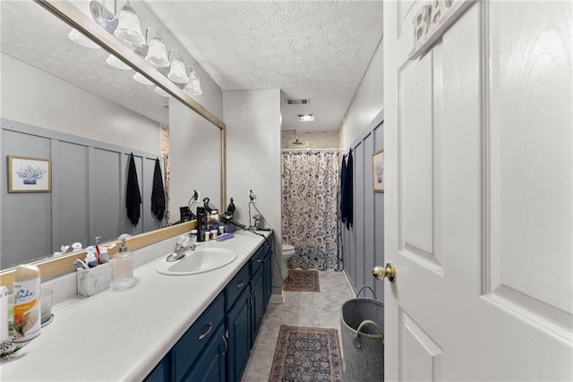 bathroom with visible vents, a shower with shower curtain, toilet, vanity, and a textured ceiling