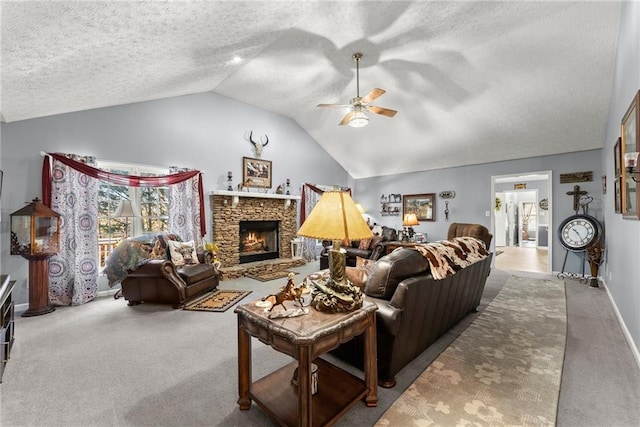 living room with a ceiling fan, vaulted ceiling, a textured ceiling, a stone fireplace, and carpet floors