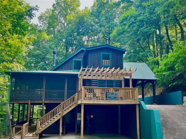 back of property featuring a wooden deck and a pergola