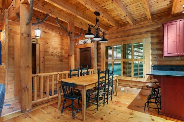 dining space featuring beamed ceiling, wood ceiling, and light hardwood / wood-style flooring