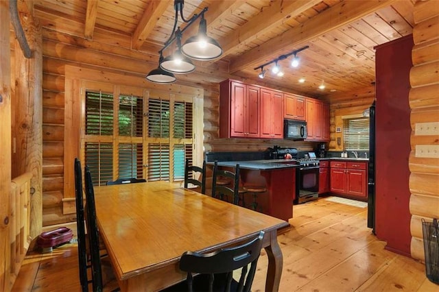 kitchen featuring pendant lighting, track lighting, black appliances, log walls, and beamed ceiling