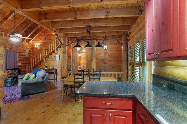 kitchen with rustic walls, vaulted ceiling with beams, wood ceiling, wood walls, and light hardwood / wood-style floors