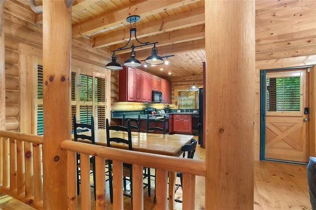 kitchen with log walls, light hardwood / wood-style flooring, decorative light fixtures, and wooden ceiling