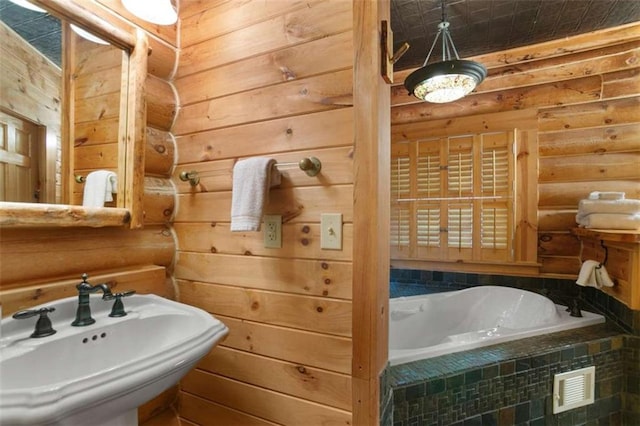 bathroom with a relaxing tiled tub, rustic walls, and sink