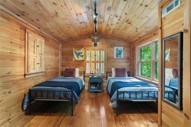 bedroom featuring hardwood / wood-style flooring, vaulted ceiling, wooden ceiling, and wooden walls