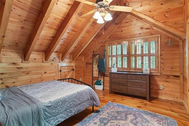 bedroom with wood walls, vaulted ceiling with beams, ceiling fan, wooden ceiling, and light hardwood / wood-style flooring