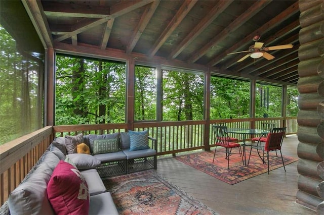 sunroom / solarium with ceiling fan and lofted ceiling with beams