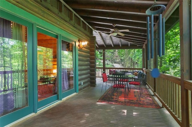 unfurnished sunroom featuring lofted ceiling with beams and ceiling fan