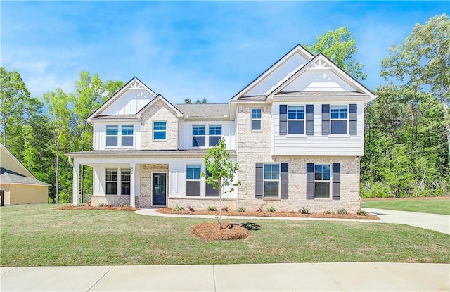 view of front of home featuring a front lawn, board and batten siding, and brick siding