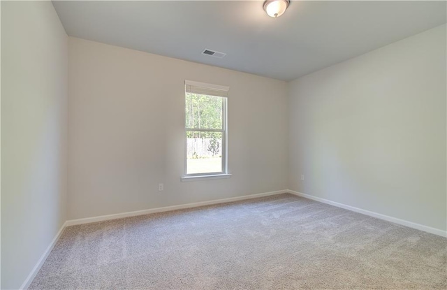 carpeted spare room with visible vents and baseboards