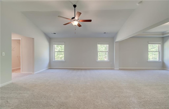 carpeted spare room featuring a ceiling fan, baseboards, visible vents, and a wealth of natural light