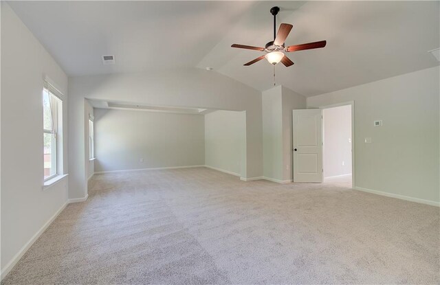 interior space with light carpet, a ceiling fan, visible vents, vaulted ceiling, and baseboards