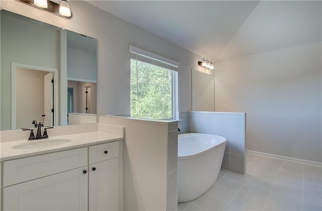 bathroom featuring a freestanding tub, vanity, and tile patterned floors