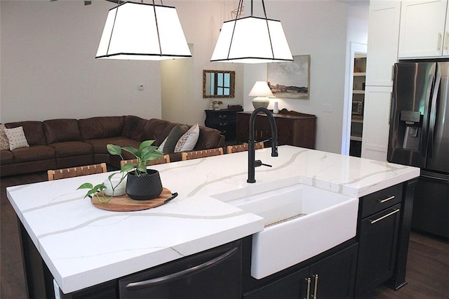688 Harmony Rd, Temple, GA 30179 - kitchen featuring refrigerator with ice dispenser, open floor plan, dark cabinetry, and light stone countertops