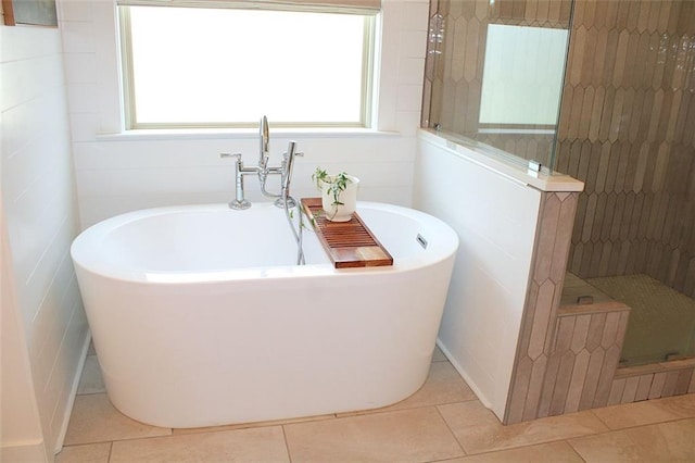 688 Harmony Rd, Temple, GA 30179 - bathroom with tile patterned floors, a freestanding tub, a stall shower, and plenty of natural light