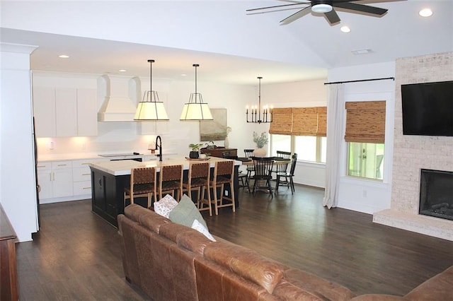 688 Harmony Rd, Temple, GA 30179 - living room featuring dark wood-type flooring, ceiling fan, recessed lighting, vaulted ceiling, and a large fireplace