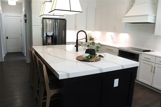 688 Harmony Rd, Temple, GA 30179 - kitchen with premium range hood, black appliances, a center island with sink, dark wood finished floors, and light stone counters