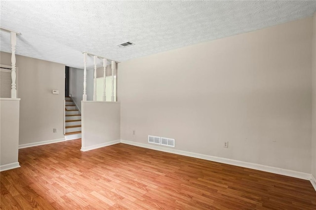 140 Carriage Cir, Stockbridge, GA 30281 - spare room featuring light wood-style flooring, stairs, and a textured ceiling
