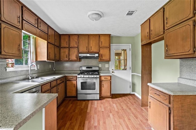 140 Carriage Cir, Stockbridge, GA 30281 - kitchen featuring stainless steel range with gas cooktop, under cabinet range hood, wood finished floors, decorative backsplash, and a textured ceiling