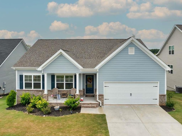 view of front facade with a porch, a garage, and a front lawn