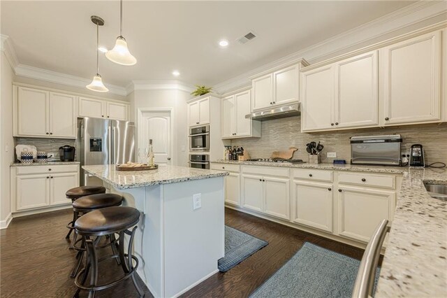 5515 Cheatam Ave, Cumming, GA 30040 - kitchen featuring stainless steel appliances, decorative backsplash, ornamental molding, dark wood-style flooring, and a center island